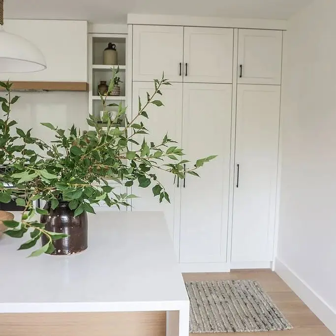 Quartz kitchen with island and pocket door cabinetry by Heirlooms Custom Cabinetry