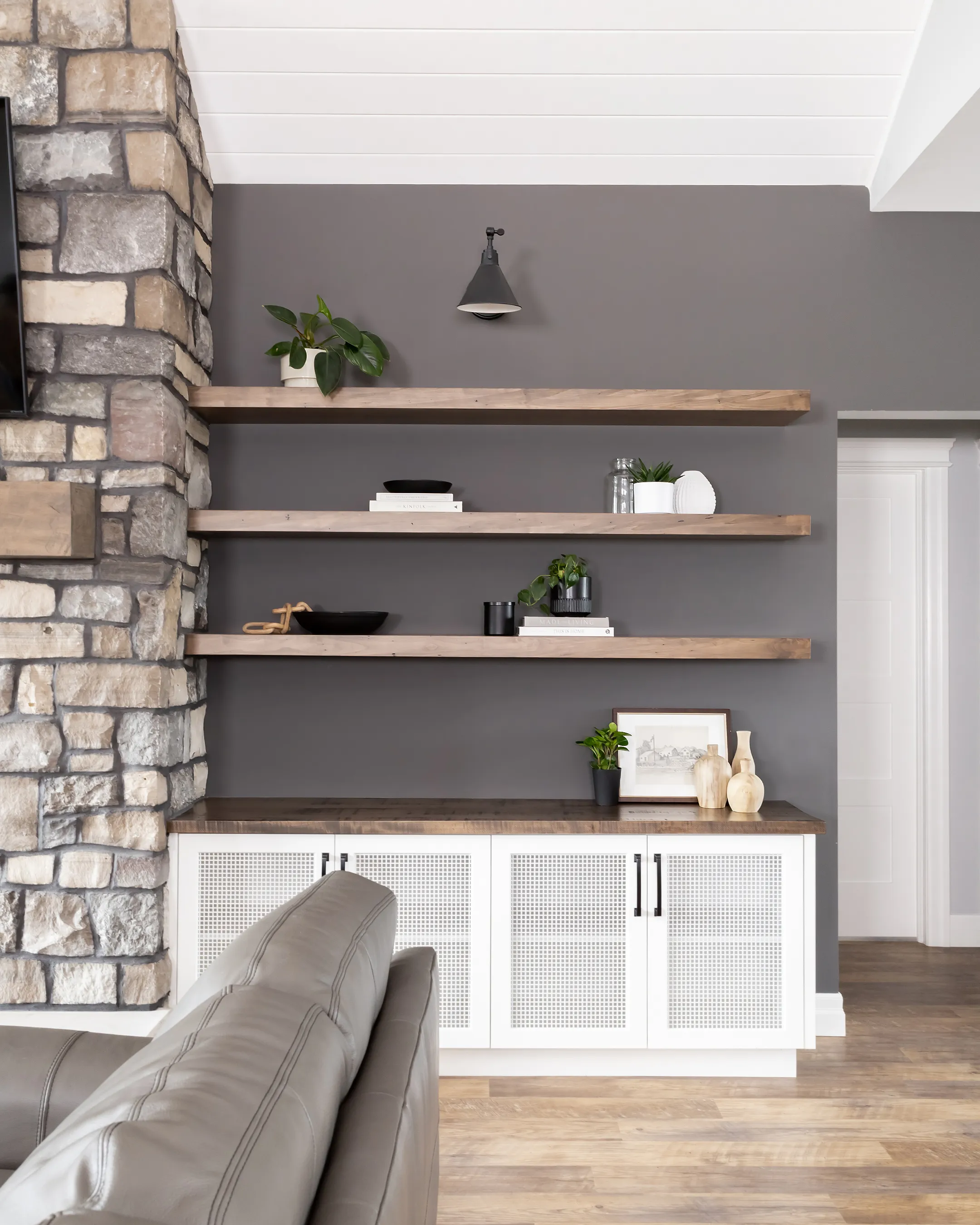 Custom built-in shelving beside stone fireplace by Heirlooms